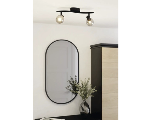 Deckenleuchte mit zwei Spots und ovaler Spiegel über Kommode