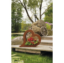 Dekoratives Herz aus Metall mit Blumen auf Holzsteg am Teich