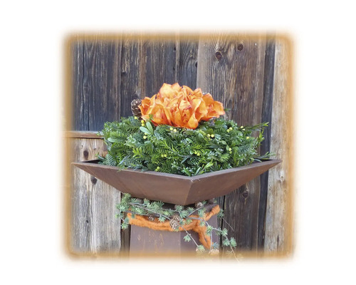 Dekoration mit Blumen in einer Metallschale auf einem Sockel