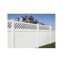 Weißer Gartenzaun mit Latten und Zierelementen vor einem Haus