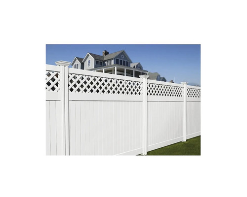 Weißer Gartenzaun mit Latten und Zierelementen vor einem Haus