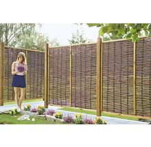 Gartenszene mit Weidenzaun und Frau mit Blumenstrauß