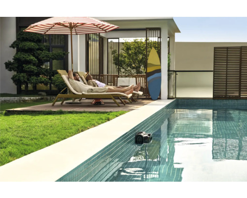 Szene mit Pool, in dem sich ein Poolroboter befindet, und zwei Personen, die sich auf Liegestühlen unter einem Sonnenschirm entspannen