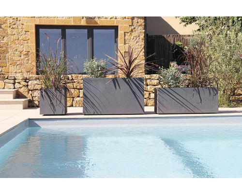 Drei bepflanzte Pflanzkübel unterschiedlicher Größe neben einem Schwimmbecken.