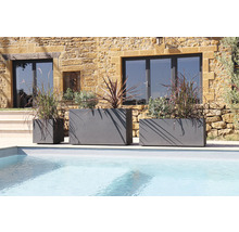 Drei graue Pflanzgefäße unterschiedlicher Größe am Pool