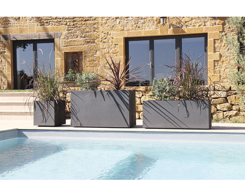 Drei graue Pflanzgefäße unterschiedlicher Größe am Pool