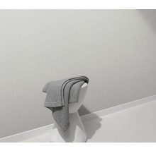 Graue Decke auf weißem Hocker in einem Badezimmer