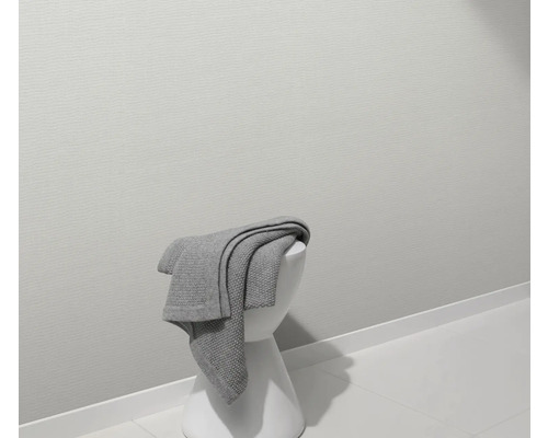 Graue Decke auf weißem Hocker in einem Badezimmer