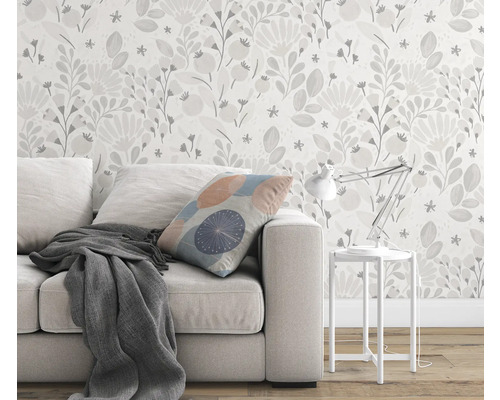 Wohnzimmer mit Sofa, Kissen, Decke, Tischlampe und Blumentapete