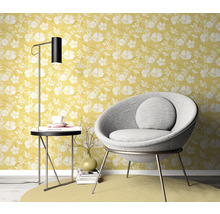 Wohnszene mit gelber Blumentapete, Sessel, Stehlampe und Beistelltisch