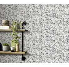 Wand mit floral gemusterter Tapete und Regalen mit Dekorationen