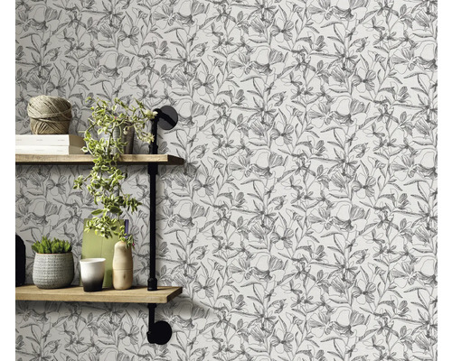 Wand mit floral gemusterter Tapete und Regalen mit Dekorationen