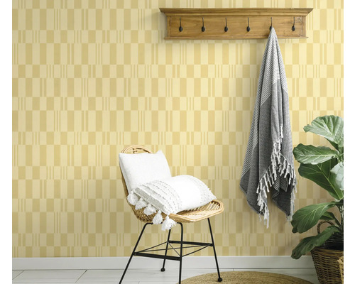 Dekoratives Interieur mit gemusterter Tapete, Stuhl, Kissen, Hakenleiste und Pflanze