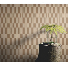 Tapete mit geometrischem Muster, arrangiert mit einem Baumstumpf als Tisch und einer Pflanze in einer Vase.