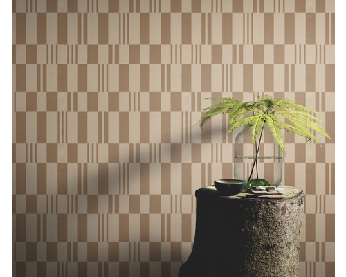 Tapete mit geometrischem Muster, arrangiert mit einem Baumstumpf als Tisch und einer Pflanze in einer Vase.