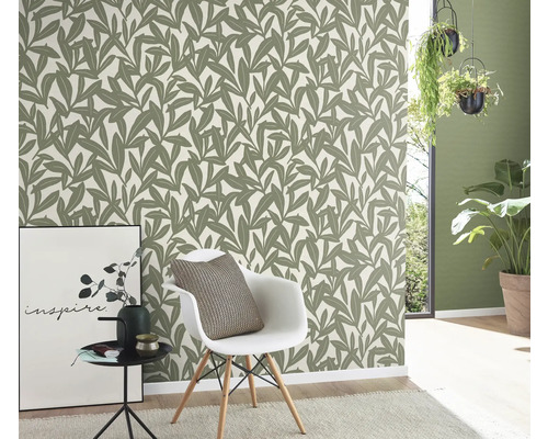 Raum mit Blättertapete, Stuhl und Dekoration für ein stilvolles Ambiente.