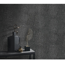 Nahaufnahme einer Wand mit Reptilleder-Tapete und Dekoration auf einem Tisch