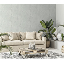 Wohnzimmer mit Sofa, Pflanzen, Couchtisch und gemusterter Tapete für eine helle und gemütliche Atmosphäre.