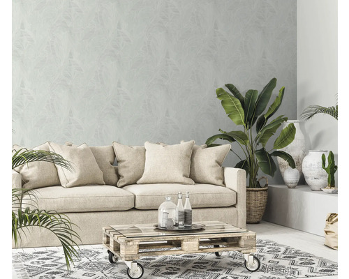 Wohnzimmer mit Sofa, Pflanzen, Couchtisch und gemusterter Tapete für eine helle und gemütliche Atmosphäre.
