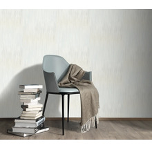 Wandgestaltung mit Tapete, Stuhl, Decke und Bücherstapel für ein gemütliches Ambiente