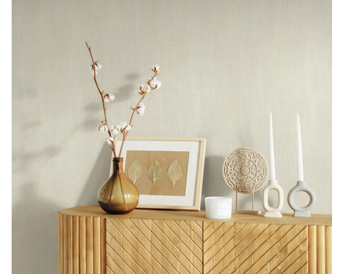 Dekoratives Arrangement auf einem Sideboard mit Vase, Baumwollzweigen, Bilderrahmen, Kerzen und Ornament