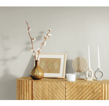 Helle, gemusterte Tapete mit Kommode, Dekoration und Pflanzen
