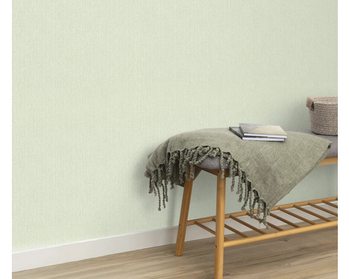 Helle Tapete an der Wand, Bank mit Decke und Büchern