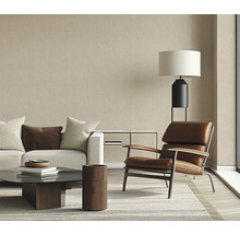 Wohnzimmer mit Sofa, Sessel, Couchtisch und Stehlampe in hellem Design.