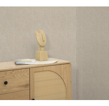 Szene mit Kommode, Deko-Skulptur und beiger Tapete