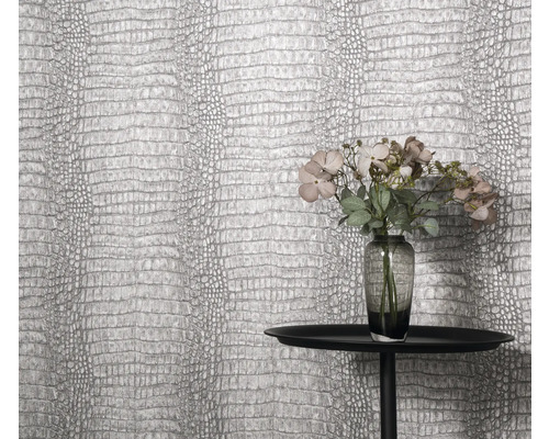 Nahaufnahme einer Wand mit Krokodilleder-Tapete, einem Tisch und Blumenvase