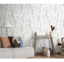 Szene mit einer Wandtapete mit floralem Design, einem Sofa und dekorativen Elementen für ein gemütliches Wohnambiente