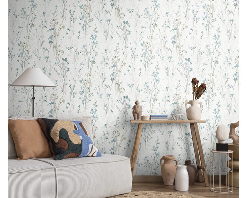 Szene mit einer Wandtapete mit floralem Design, einem Sofa und dekorativen Elementen für ein gemütliches Wohnambiente