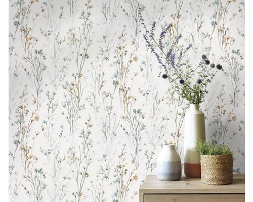 Tapete mit zartem Blumenmuster und verschiedenen Dekorationsgegenständen auf einer Kommode.