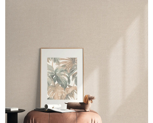 Szene mit einem gerahmten Bild mit Pflanzenmotiven auf einem Hocker vor einer Textiltapete.