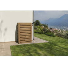 Wand-Regenspeicher in Holzoptik mit Zapfhahn an einer weißen Hauswand in einem hellen Garten mit Blick auf Berge.