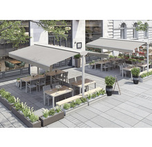 Außenbereich eines Restaurants mit Markisen, Tischen, Stühlen und Bepflanzung