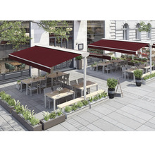 Außenbereich eines Restaurants mit Markisen, Tischen und Bepflanzung