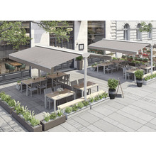 Außenbereich eines Restaurants mit Markisen, Tischen, Stühlen und Pflanzenkästen.