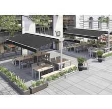 Außenbereich eines Restaurants mit Markisen, Tischen und Bepflanzung