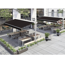 Außenbereich eines Restaurants mit Markisen, Tischen und Bepflanzung