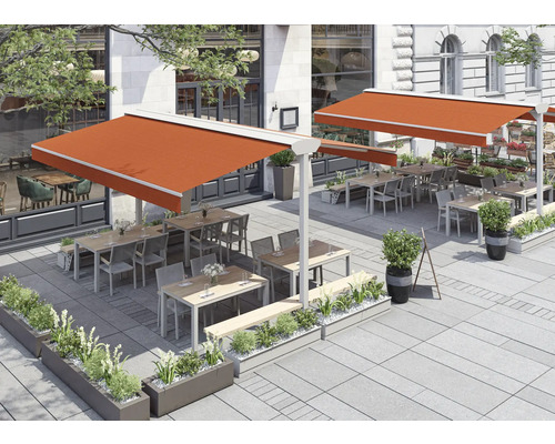 Terrasse mit Markisen, Tischen, Stühlen und Bepflanzung vor einem Gebäude