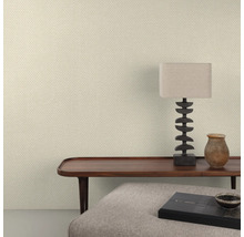 Raumansicht mit gemusterter Tapete, Tisch, Lampe und Dekoration