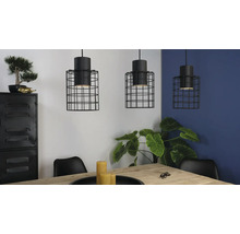 Drei Hängelampen mit schwarzem Drahtkäfig über einem Esstisch in einem hellen Raum