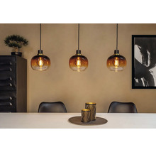 Szene mit drei Pendelleuchten aus Glas über einem Esstisch