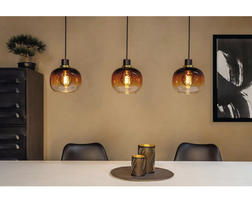 Szene mit drei Pendelleuchten aus Glas über einem Esstisch