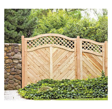 Holzzaun mit Rautenmuster und Steinmauer im Garten