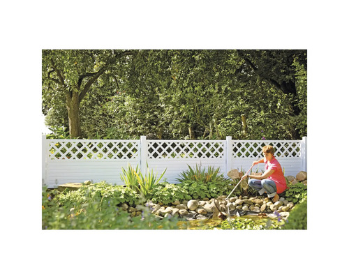 Gartenszene mit einem weißen Zaun und einer Person, die einen Teich reinigt