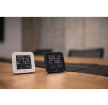 Zwei digitale Thermometer und Hygrometer in Weiß und Schwarz auf einem Holztisch, die 27,2 Grad Celsius und 41 Prozent Luftfeuchtigkeit anzeigen.