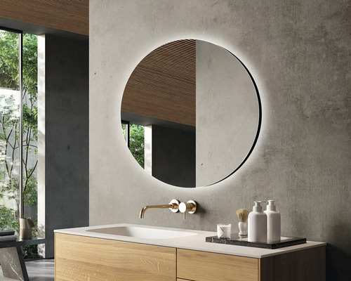 Modernes Badezimmer mit rundem Spiegel, Waschtisch und Armatur.