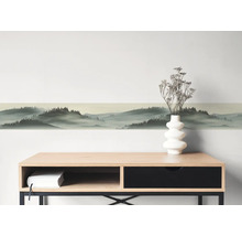 Selbstklebende Wandbordüre mit Waldlandschaft und Nebeleffekt über einem Sideboard.